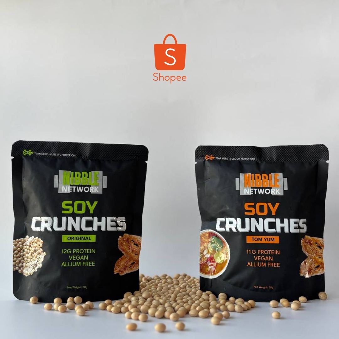 Two packages of Nibble Network Soy Crunches with scattered soybeans on a gray background, featuring the Shopee logo.